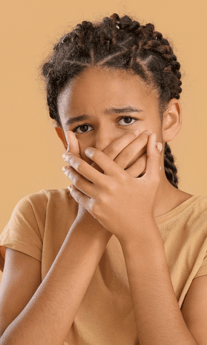 A 5th grader covering her mouth, portraying the need for cosmetic dentistry due to fluorosis stains